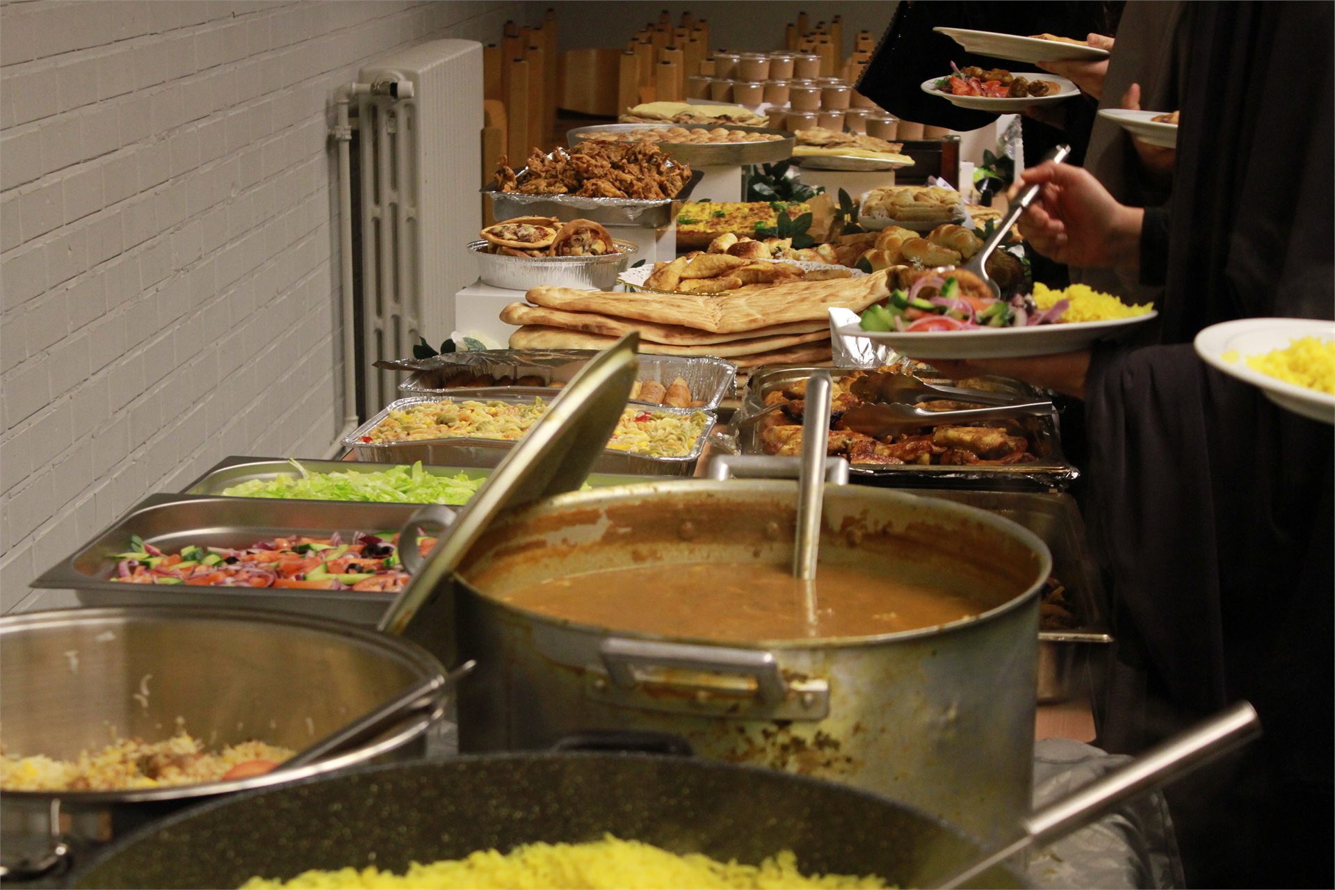 Gasten die gerechten opscheppen aan het iftarbuffet
